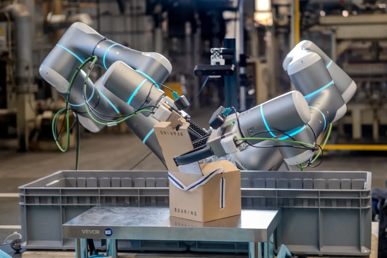 Two robot arms handling a box at Rhoda AI